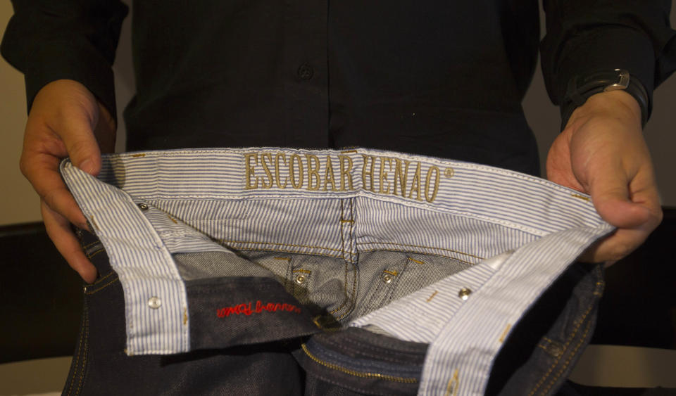 Sebastian Marroquin, son of Colombia's late drug lord Pablo Escobar, shows a pair of pants from his collection "Escobar Henao" at his home in Buenos Aires, Argentina, Friday, Aug. 17, 2012. Marroquin, who legally changed his name and moved to Argentina in 1994 with his mother Maria Valeria Henao after his father was killed, says he created the collection as a way to send a message of peace and reflection about his family's history. (AP Photo/Eduardo Di Baia)