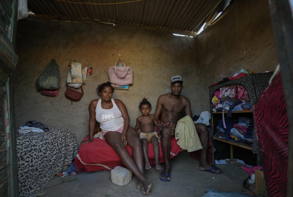 Husband and wife Ivan Alcantara and Cristiana Santos pose for a photo with their two-year-old daughter Rafaela at their home in Aracuai, Minas Geraes state, Brazil, Tuesday, Oct. 11, 2022. The couple are unemployed and rely on government aid but say it is not enough and they regularly go hungry. Brazil will hold a presidential run-off election on Oct. 30. (AP Photo/Andre Penner)