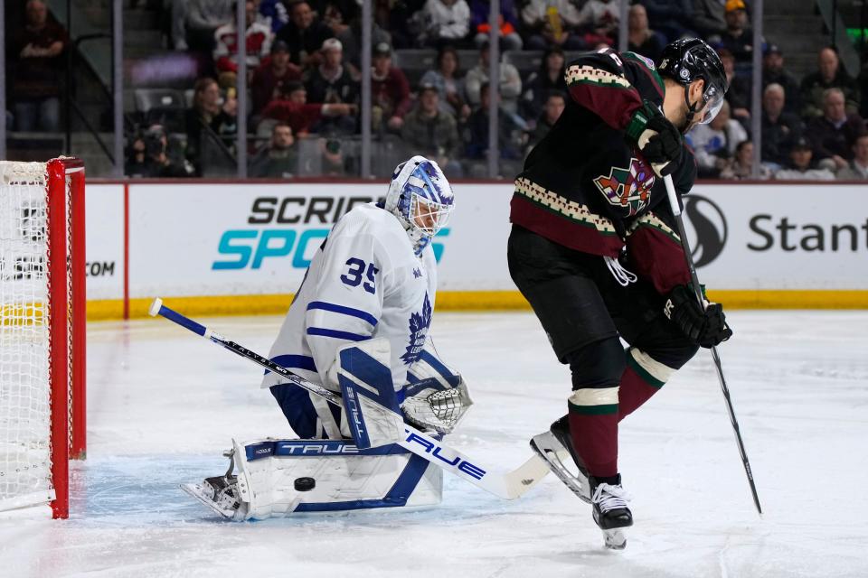 Toronto Maple Leafs goaltender Ilya Samsonov (35) makes a save n3ext to Arizona Coyotes left wing Jason Zucker during the third period of an NHL hockey game Wednesday, Feb. 21, 2024, in Tempe, Ariz. (AP Photo/Rick Scuteri)