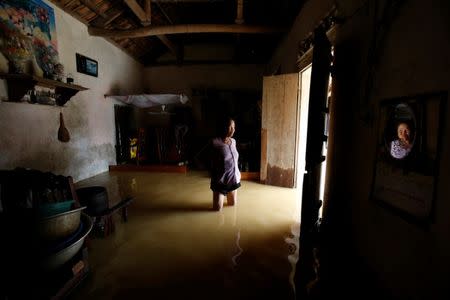 A farmer stands in her flooded house after a tropical depression in Hanoi, Vietnam October 13, 2017. REUTERS/Kham