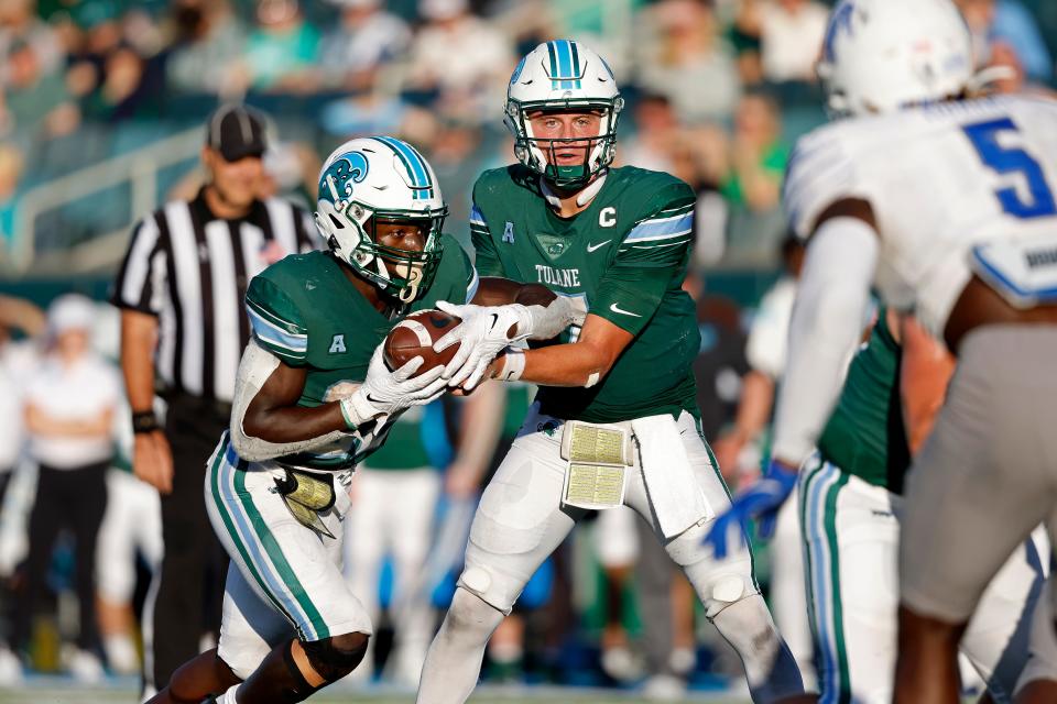 Tulane quarterback Michael Pratt (7) hands the ball to running back Tyjae Spears (22) during the second half of an NCAA college football game against Memphis in New Orleans, Saturday, Oct. 22, 2022. Tulane won 38-28. (AP Photo/Tyler Kaufman)