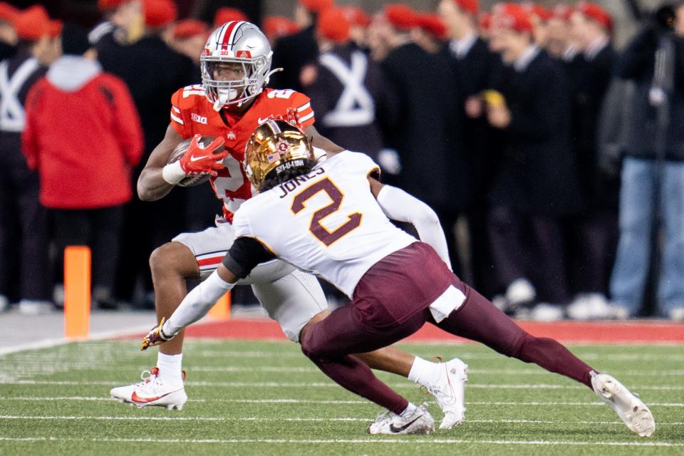 Nov 18, 2023; Columbus, Ohio, USA; 
Ohio State Buckeyes running back Evan Pryor (21) attempts to run past Minnesota Golden Gophers defensive back Tre'Von Jones (2) during the second half of their game on Saturday, Nov. 18, 2023 at Ohio Stadium.