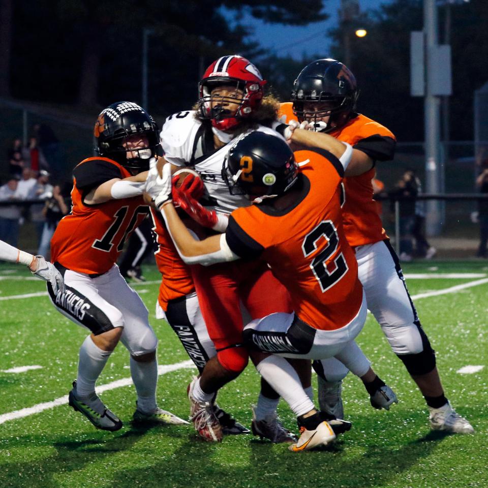 New Lexington's Bentley Hanson, left, Chase Dumolt and Elijah Stephens swarm Coshocton's Israel Rice during the second quarter of a regular season contest. Hanson and Dumolt were Division V first-team selections in the Southeast District.