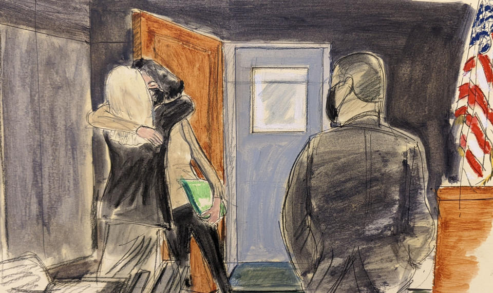 FILE - In this courtroom sketch, Ghislaine Maxwell, center, hugs her defense attorney, Laura Menninger, immediately after walking out of lock-up after a four day break during Maxwell's sex trafficking trial, Monday, Dec. 27, 2021, in New York. (AP Photo/Elizabeth Williams, File)