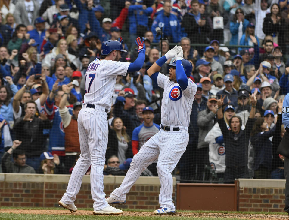 Chicago Cubs' Kris Bryant (17) and Willson Contreras, right, high five after they score on Contreras' home run during the fifth inning of a baseball game against the St. Louis Cardinals on Sunday, Sept. 30, 2018, in Chicago. (AP Photo/Matt Marton)