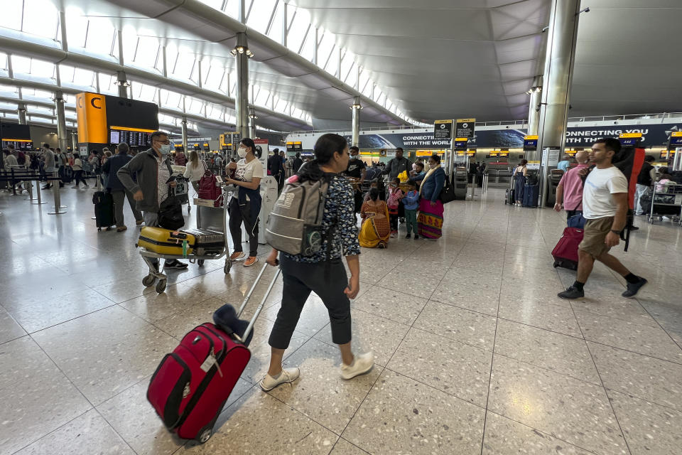 FILE - Travelers at Heathrow Airport in London, Wednesday, July 13, 2022. Mixed signals are emerging about travel in Europe heading into the winter season. British Airways is cutting more than 10,000 short-haul flights in and out of Heathrow Airport through March 2023, while nearby Gatwick Airport is ending its limits on the number of daily flights. (AP Photo/Alberto Pezzali, File)