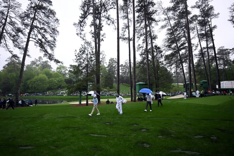 Players walk by the location where trees fell due to weather on the 17th hole last year during the second round of the Masters (ROSS KINNAIRD)