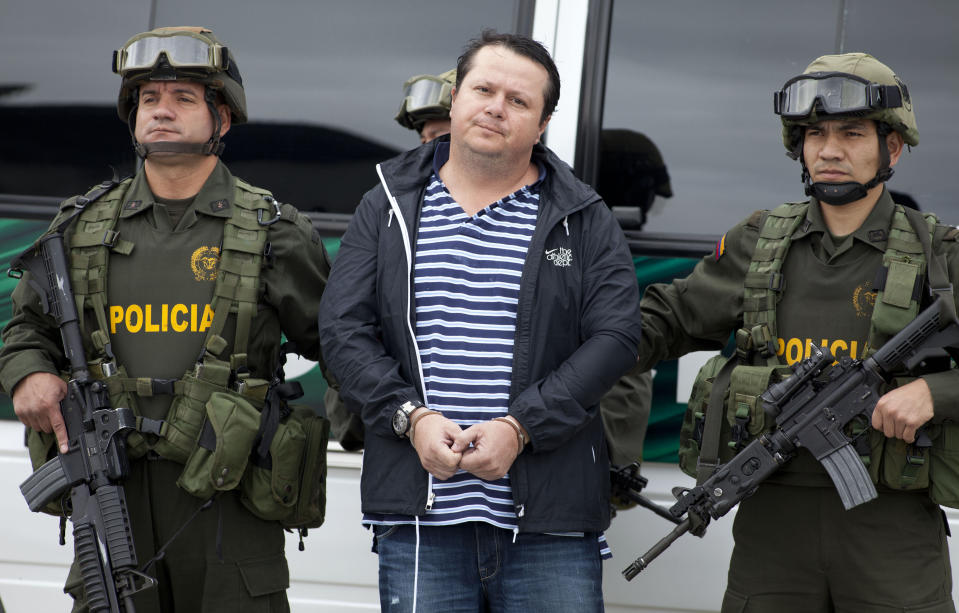 Police officers escort Costa Rican Alejandro Jimenez Gonzalez to a police station in Bogota, Colombia, Tuesday March 13, 2012. Jimenez is suspected of ordering the attack that resulted in the murder of Argentine folk singer Facundo Cabral, who was gunned down last year in an ambush in Guatemala. Authorities believe the attack was aimed at the Nicaraguan businessman who was driving the singer to the airport. That man was wounded. (AP Photo/Fernando Vergara)