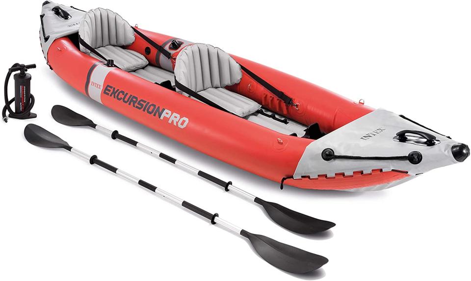 Intex Excursion Pro Kayak in red with two paddles laying beside it