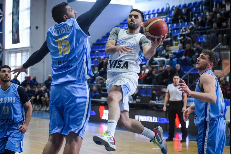 Campazzo penetra con una bandeja contra el grandote Esteban Batista en uno de los dos amistosos que la Argentina le ganó a Uruguay como preparación.