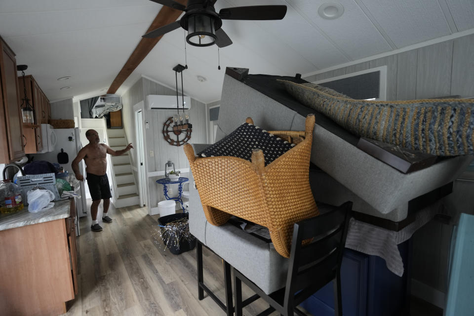 Furniture is piled high inside a canal-front second home of Victor Cassano in Suwannee, Fla., as he prepares for the expected arrival of Hurricane Idalia, Tuesday, Aug. 29, 2023. Cassano, a flooring contractor, has meticulously constructed and outfitted the small two-bedroom home which he is hoping to move into full-time as soon as he can sell his house in Ormond Beach, Fla. (AP Photo/Rebecca Blackwell)