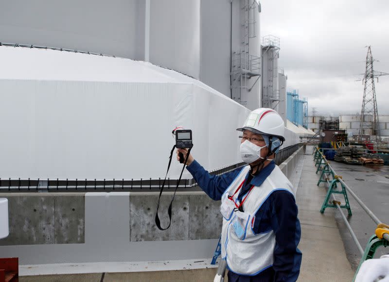 FILE PHOTO: A Tokyo Electric Power Co (TEPCO) employee uses a geiger counter at the company's tsunami-crippled Fukushima nuclear plant