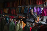 In this Jan. 30, 2020, photo,Kashmiri shopkeeper Mohammad Ashraf browses the internet on his mobile phone in Srinagar, Indian controlled Kashmir. Six months after India stripped restive Kashmir of its semi-autonomy, enforcing a total communications blackout, it has restored limited internet at slow speeds with access only to government-approved websites. Since Modi came into power in 2014, the internet has been suspended more than 365 times in India, according to the global digital rights group Access Now. (AP Photo/ Dar Yasin)