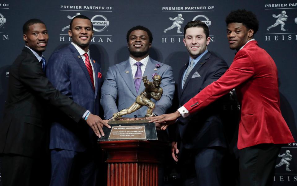 Heisman Trophy finalists, from left, Oklahoma's Dede Westbrook, Clemson's Deshaun Watson, Michigan's Jabrill Peppers, Oklahoma's Baker Mayfield and Louisville's Lamar Jackson stand for a photo with the Heisman Trophy before attending the Heisman Trophy award ceremony Dec. 10, 2016, in New York.