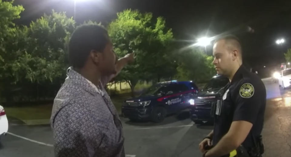 Rayshard Brooks, 27, speaks with Atlanta police officer Garrett Rolfe in a Wendy's car park.