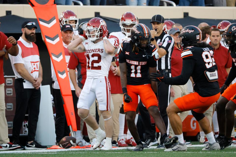 Oklahoma State Cowboys cornerback Dylan Smith (11) and defensive end Nathan Latu (92) celebrate next to Oklahoma Sooners wide receiver Drake Stoops (12) after a fourth down stop late in the fourth quarter of a Bedlam college football game between the Oklahoma State University Cowboys (OSU) and the University of Oklahoma Sooners (OU) at Boone Pickens Stadium in Stillwater, Okla., Saturday, Nov. 4, 2023. Oklahoma State won 27-24.