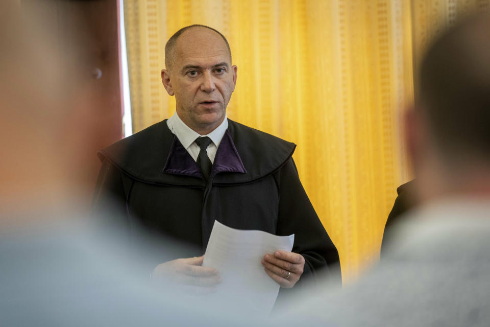 Judge Erik Mezolaki announces the second verdict in the migrant smuggling case known as the Parndorf-case in the Court of Appeal of Szeged in Szeged, southern Hungary, Thursday, June 20, 2019. Hungarian court has extended the prison sentences of four human traffickers convicted last year for their roles in a 2015 in which 71 migrants suffocated to death in the back of a refrigerated truck found on a highway in Austria. (Tibor Rosta/MTI via AP)