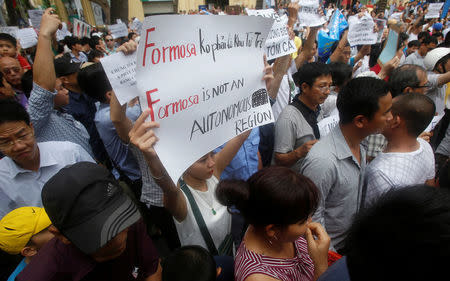 Demonstrators, holding signs to protest against Taiwanese enterprise Formosa Plastic and environmental-friendly messages, say they are demanding cleaner waters in the central regions after mass fish deaths in recent weeks, in Hanoi, Vietnam May 1, 2016. REUTERS/Kham