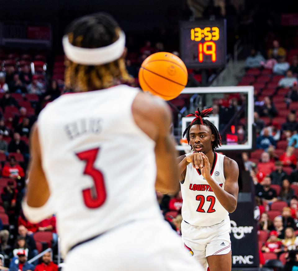 Louisville's Kamari Lands (22) whipped a pass to teammate El Ellis (3) during first half action as the Cards fall to Lipscomb 75-67 at the Yum! Center in downtown Louisville Tuesday night. Dec. 20, 2022