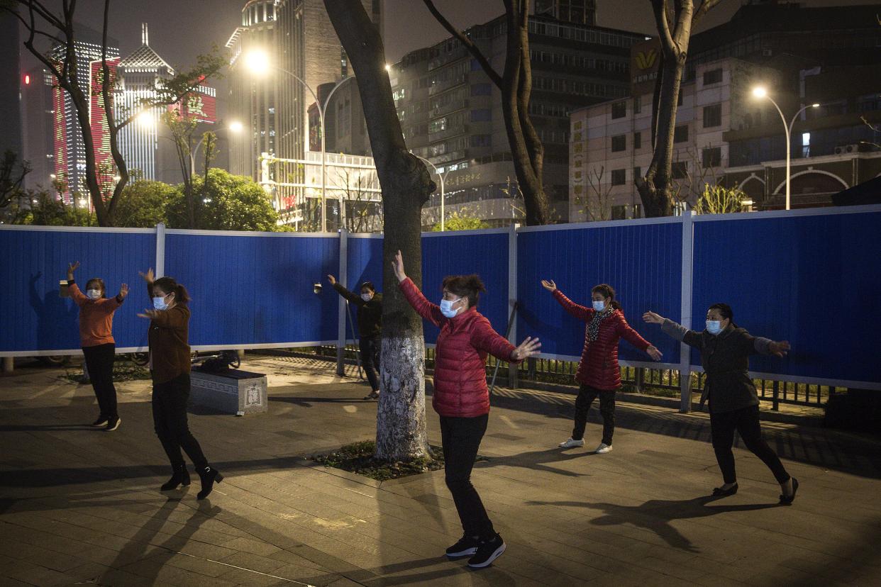 Local women perform a square dance inside a makeshift barricade wall built to control entry and exit to a residential compound at a community on April 2, 2020, in Wuhan, China. The government stipulates that residents with green health code can go out in public. Wuhan, the central Chinese city where the coronavirus (COVID-19) first emerged last year, will lift its lockdown on April 8, local media reported.