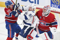 Montreal Canadiens' Alex Newhook, left, defends against Tampa Bay Lightning's Steven Stamkos (91) as Canadiens goaltender Cayden Primeau looks on during first-period NHL hockey game action in Montreal, Thursday, April 4, 2024. (Graham Hughes/The Canadian Press via AP)