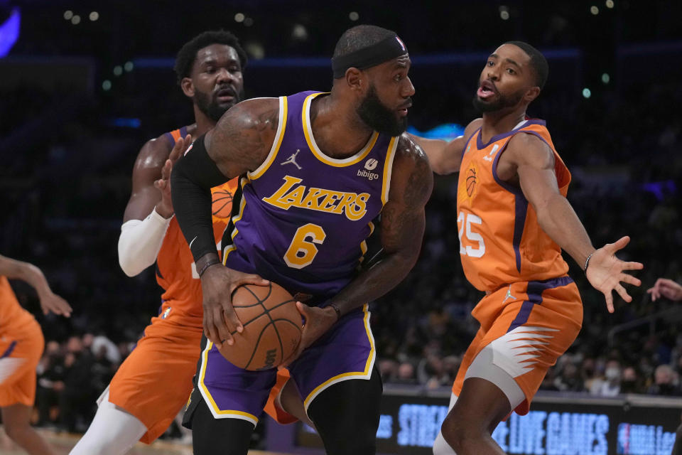 Oct 22, 2021; Los Angeles, California, USA; Los Angeles Lakers forward LeBron James (6) is defended by Phoenix Suns forward Mikal Bridges (25) and center Deandre Ayton (22) in the first half at Staples Center.