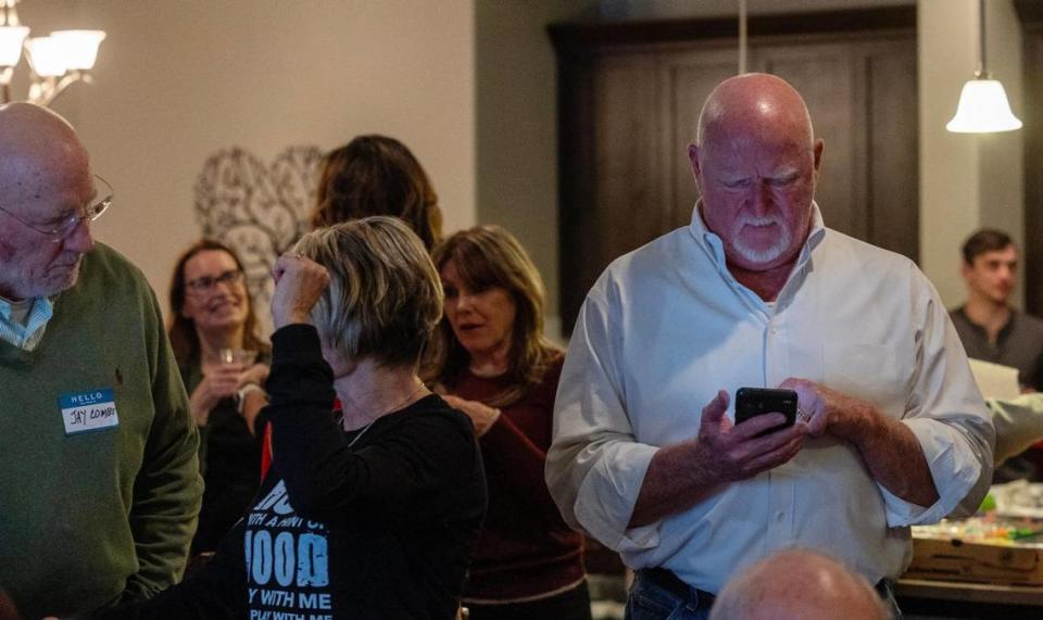 Eagle City Council President Brad Pike checks his phone for the latest election results during his election night watch party at his home in Eagle