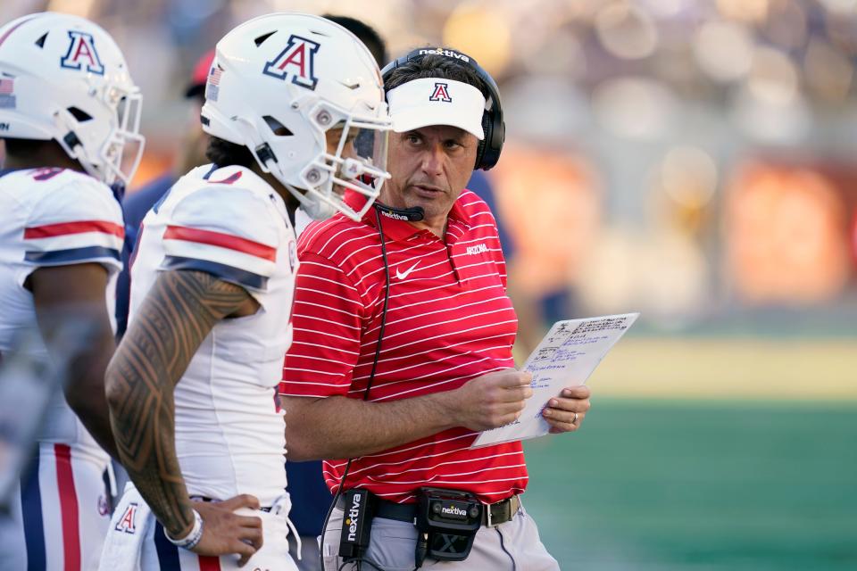 Arizona head coach Jedd Fisch, right, talks with quarterback Jayden de Laura, second from left, before the offense took the field against California during the second half of an NCAA college football game in Berkeley, Calif., Saturday, Sept. 24, 2022. (AP Photo/Godofredo A. VÃ¡squez)