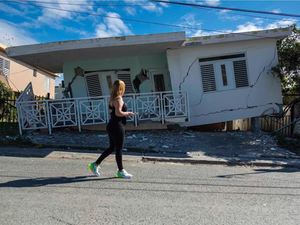 woman outside a collapsed house in Puerto rico 