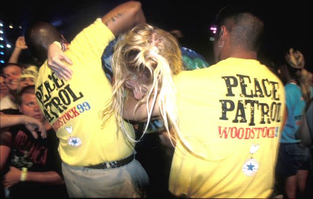 A young woman is pulled out of a violent crowd at Woodstock '99 by festival security. (Photo: Netflix)