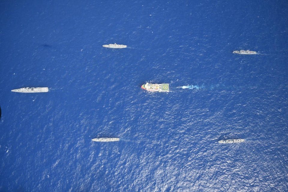 In this photo provided by the Turkish Defense Ministry, Turkey's research vessel, Oruc Reis, in red and white, is surrounded by Turkish navy vessels as it was heading in the west of Antalya on the Mediterranean, Turkey, Monday, Aug 10, 2020. Tension remains high between Greece and Turkey, whose warships are in the eastern Mediterranean where Turkey has sent a research vessel to carry out seismic research for energy resources in an area Greece says is on its continental shelf.(Turkish Defense Ministry via AP, Pool)