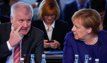 German Chancellor Angela Merkel and Interior Minister Horst Seehofer take part in a conference about the equal living conditions between urban and rural areas in Berlin, Germany September 26, 2018. REUTERS/Hannibach Hanschke