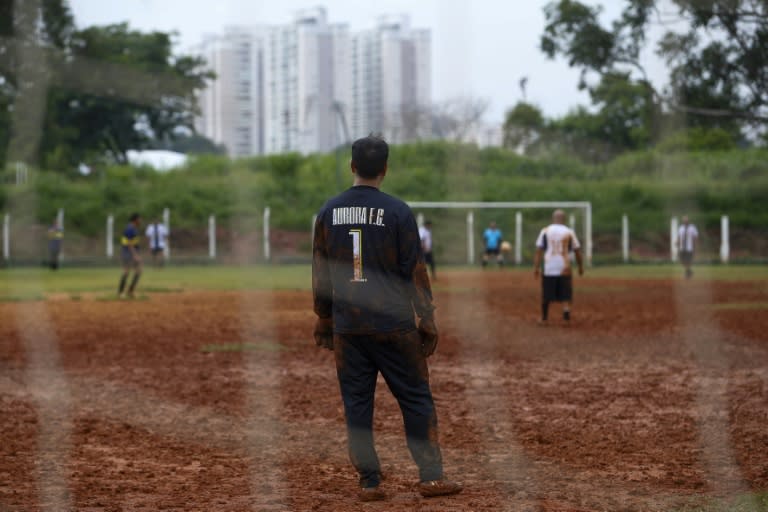 Unos aficionados juegan al fútbol en un campo de tierra en Sao Paulo el 17 de febrero de 2024 (Miguel Schincariol)