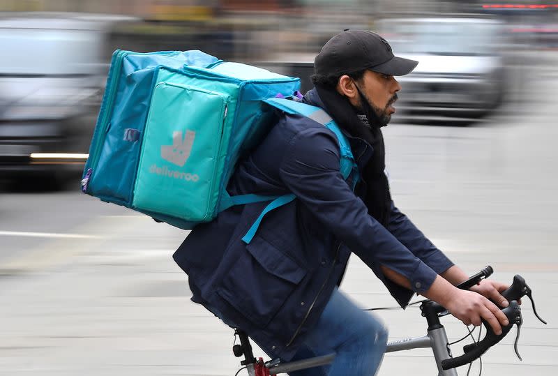 A Deliveroo delivery rider cycles in London