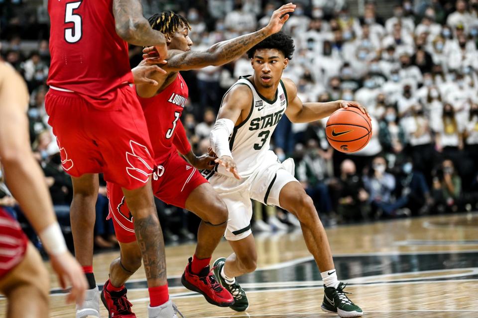 Michigan State's Jaden Akins, right, moves past Louisville's El Ellis during the first half on Wednesday, Dec. 1, 2021, at the Breslin Center in East Lansing.