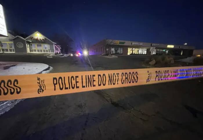 a stretch of caution tape that reads "police line do not cross" across a dark suburban night