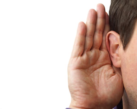 Man holding his right hand cupped over his ear