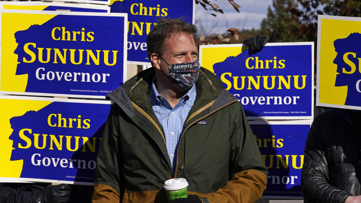 N.H. Gov. Chris Sununu stands with supporters at a polling station at Windham, N.H. High School, Tuesday, Nov. 3, 2020, in Windham. Sununu, a Republican, faces Democrat Dan Feltes in the gubernatorial election. (AP Photo/Charles Krupa)