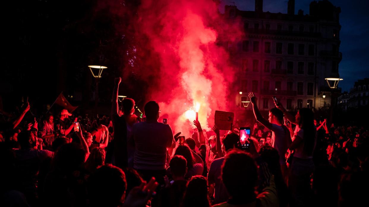  Left wing supporters light red flares as they celebrate during a rally after the announcement of the results of the second round of France's parliamentary elections. 