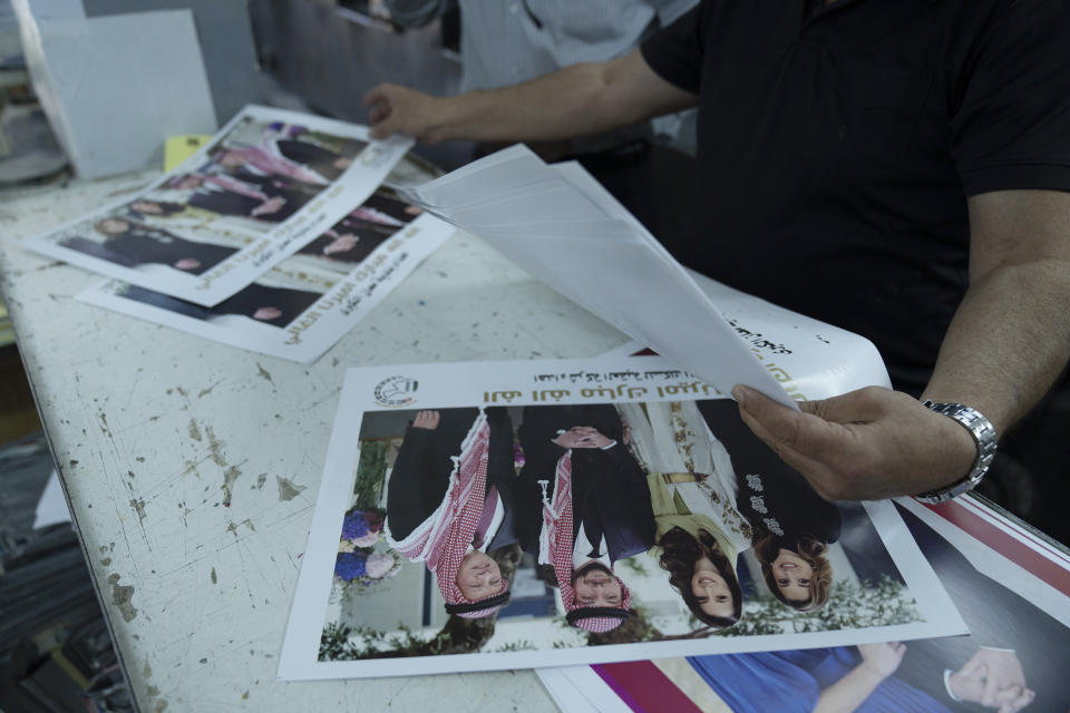 A Jordanian specialist follows the process of printing posters with pictures of, from left, King Abdullah II, Crown Prince Hussein, Saudi architect Rajwa Alseif and Queen Rania, at a print house in Amman, Jordan, Wednesday, May 31, 2023. Crown Prince Hussein and Saudi architect Rajwa Alseif are to be married on Thursday at a palace wedding in Jordan, a Western-allied monarchy that has been a bastion of stability for decades as Middle East turmoil has lapped at its borders. (AP Photo/Nasser Nasser)