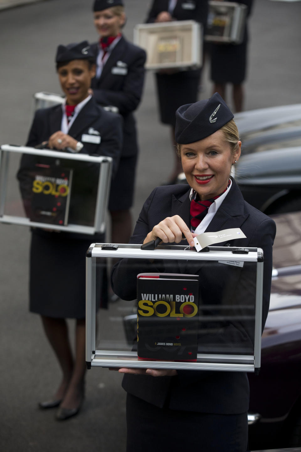 Flight attendants pose for photographers with copies of the new James Bond novel "Solo" during a launch photocall outside the Dorchester Hotel in London, Wednesday, Sept. 25, 2013. "Solo" is set in 1969 and takes the suave British spy, 45 years old and feeling his age, from London's plush Dorchester Hotel to a war-torn West African country and to Washington. (AP Photo/Matt Dunham)