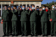 Chinese paramilitary policemen put on their face masks to help curb the spread of the coronavirus arrive to the Great Hall of the People to attend the commemorating conference on the 70th anniversary of China's entry into the 1950-53 Korean War, in Beijing Friday, Oct. 23, 2020. (AP Photo/Andy Wong)