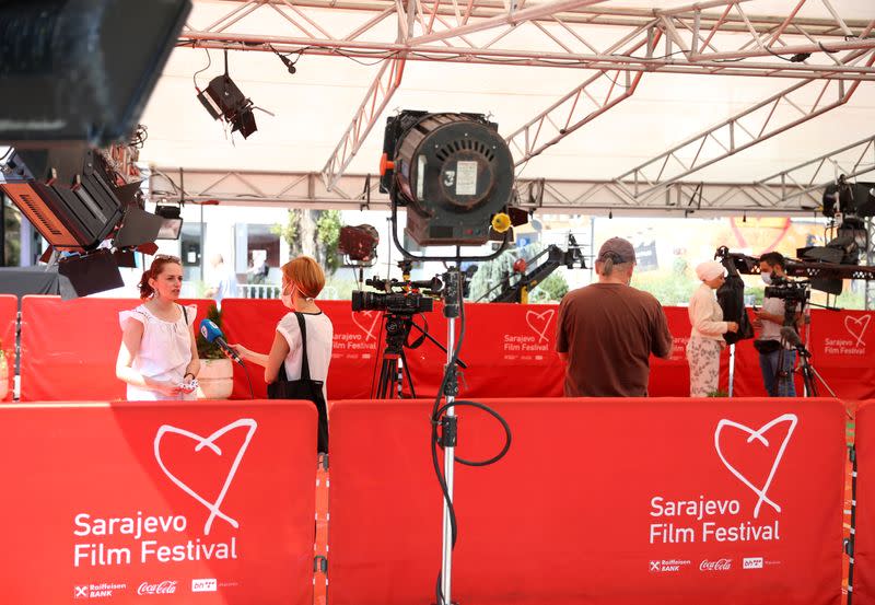 TV reporters stand on the red carpet before the online opening ceremony of the Sarajevo Film Festival in Sarajevo