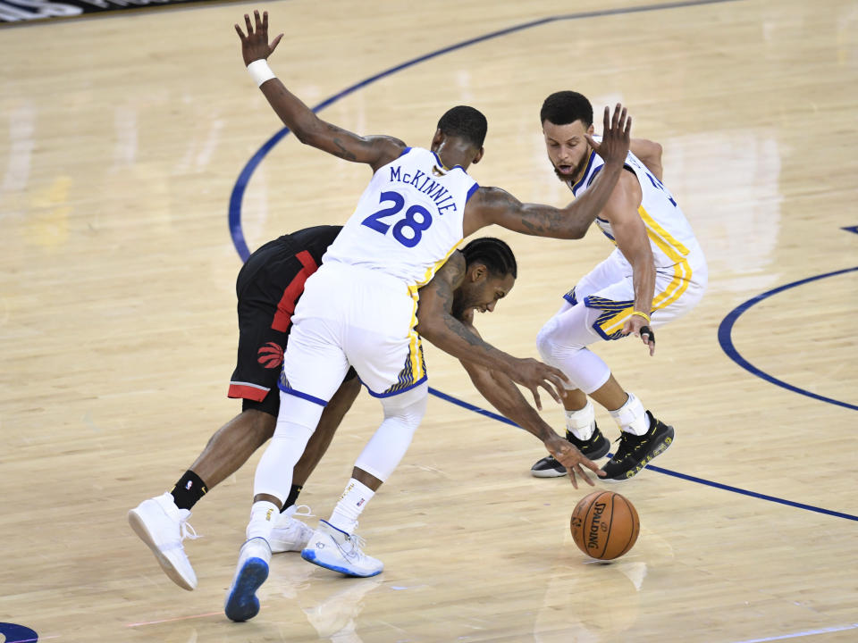 Toronto Raptors forward Kawhi Leonard (2) works between Golden State Warriors forward Alfonzo McKinnie (28) and guard Stephen Curry for the ball during the second half of Game 3 of basketball’s NBA Finals, Wednesday, June 5, 2019, in Oakland, Calif. (Frank Gunn/The Canadian Press via AP)