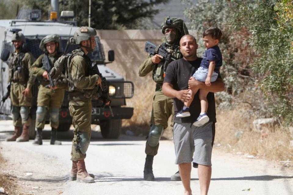 <div class="inline-image__caption"><p>Israeli soldiers prevent Palestinians from passing after blocking the road during a military operation.</p></div> <div class="inline-image__credit">Nasser Ishtayeh/SOPA Images/LightRocket via Getty</div>