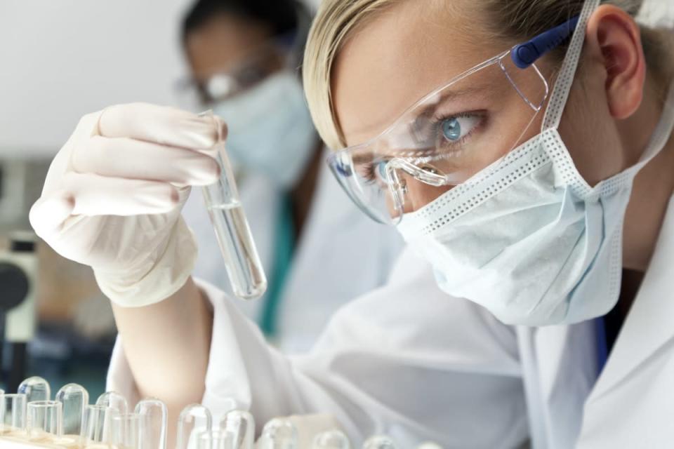 medical or scientific researcher or doctor using looking at a clear solution in a laboratory