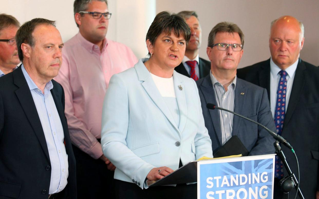 Democratic Unionist Party leader Arlene Foster and speaks to the media, surrounded by her party Members of Parliament - AP