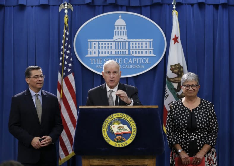 Gov. Jerry Brown, flanked by California Attorney General Xavier Becerra, left, and California Air Resources Board Chair Mary Nichols, discusses a lawsuit filed by 17 states and the District of Columbia over the Trump administration's plans to scrap vehicle emission standards during a news conference Tuesday, May 1, 2018, in Sacramento, Calif. The U.S. Environmental Protection Agency has moved to roll back tailpipe emissions standards for vehicles manufactured between 2022 and 2025. (AP Photo/Rich Pedroncelli)