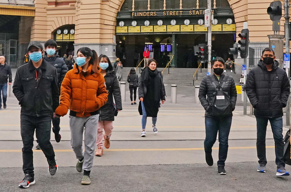 People leave Flinders Street Station wearing face masks on Sunday. Source: AAP