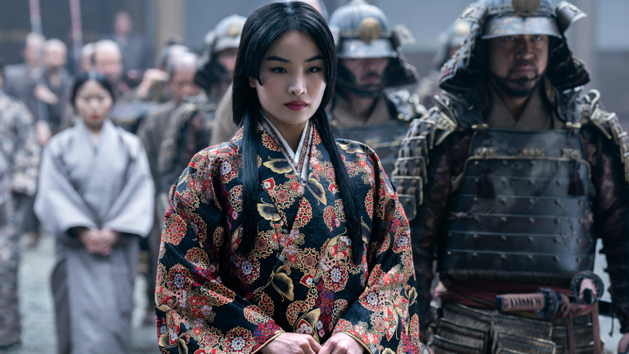  Anna Sawai stands defiantly next to an armored guard in Shōgun. 